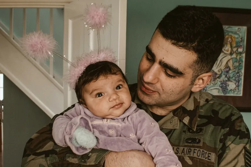 Gaston Sitbon in U.S. Air Force uniform, holding his infant daughter. England, 2009.